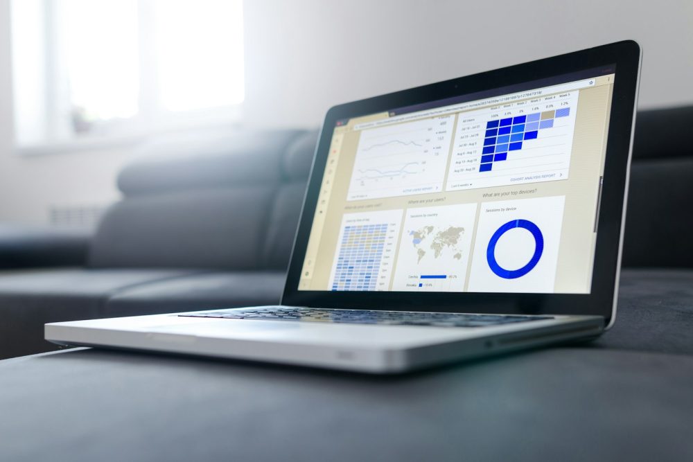 A laptop showing charts on a sofa